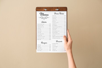 Female hand with menu on color background