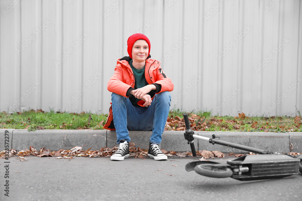 Teenage boy with kick scooter outdoors