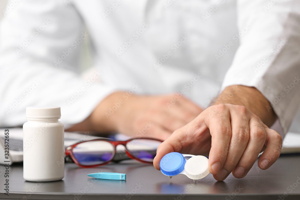 Ophthalmologist taking contact lenses from table, closeup