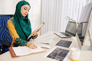 Wall Mural - female software engineer checking docudfhjdhgfjhsdfkhkjfhkdsjhfkjhdfkjdhts with printed out programm