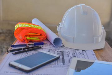 White hard hat Smart phone blueprint tool equipment on desk