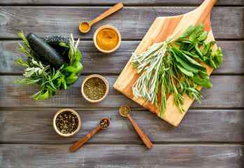 Wall Mural - Herbs and spices on dark wooden kitchen desk top-down