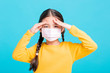 © Tom Wang - sick Girl child in medical mask isolated on blue background