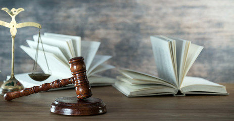 Wall Mural - Law and Justice concept. Mallet of the judge, books, scales of justice. Gray stone background, reflections on the floor, place for typography. Courtroom theme.. Wooden rustic background