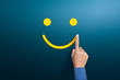 © Worawut - Customer service evaluation and satisfaction survey concepts, The client's hand draws a smile of happy face on blue background
