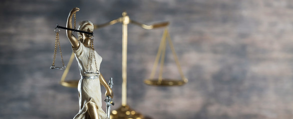 Law and Justice concept. Mallet of the judge, books, scales of justice. Gray stone background, reflections on the floor, place for typography. Courtroom theme.. Wooden rustic background