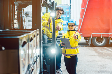 Wall Mural - Forklift driver and forewoman discussing where to store delivery