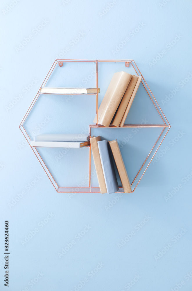 Shelf with books on light wall