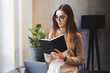 © foxyburrow - Female student writing in copybook preparing report for seminar. Young specialist making draft of work plan. Manager making list of tasks for future creative project. Concentrated lady busy at work
