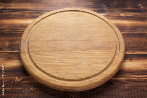 Fotografía pizza cutting board at rustic wooden plank background