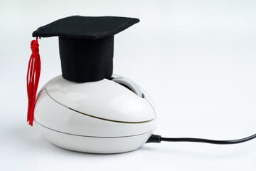 Online course, e-learning or internet study via website and online teaching concept, graduation hat on computer mouse on white background