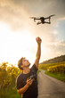 © lightpoet - Young man flying a drone in warm evening sunlight