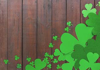 fortune, luck and st patricks day concept - green paper shamrocks on wooden background