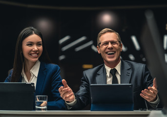 Wall Mural - The smiling man and woman sitting at the table on business conference