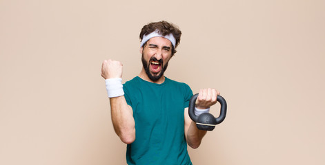 Wall Mural - young cool bearded man at gym with a dumbbell. sport concept