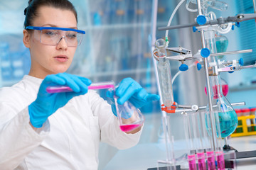 Wall Mural - Young woman in chemical lab Young woman in chemical lab. cience professional pipetting solution into the glass cuvette.