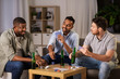© Syda Productions - leisure games, friendship and gambling concept - happy male friends playing cards and drinking beer at home at night
