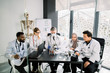© sofiko14 - Group of multiethnic scientists and senior male supervisor working with microscope and test tubes in modern science research laboratory. Biochemistry, genetics, medicine, microbiology concept