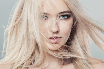 Beautiful blonde woman with long healthy blowing hair and natural skin