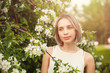 © artmim - Young woman in spring flowers garden