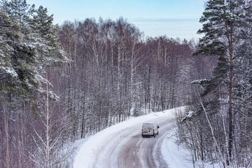 Car on the road in the winter forest.