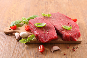 Wall Mural - raw piece of beef on board with garlic and basil