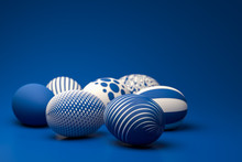 Easter Eggs With Different Textures In Classic Blue On A Seamless Blue Background. Selective Focus On Foreground.