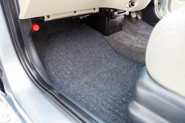 Clean car floor mats of black carpet under front passenger seat in the workshop for the detailing vehicle before dry cleaning. Auto service industry. Interior of sedan.