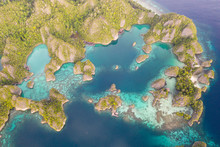 Rugged Limestone Islands Rise From The Serene Seascape In Raja Ampat, Indonesia. This Tropical Region Is Known As The Heart Of The Coral Triangle Due To Its Incredible Marine Biodiversity.