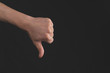 Thumbs down hand isolated on black background