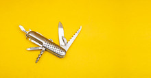 Close Up Photo Of Swiss Army Knife On Yellow Background With Copy Space