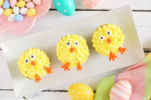 Cute Easter Chick Cupcakes. Top View Table Scene With A White Wood Background.