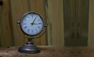 Close up vintage table clock on wooden background with copy space