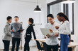 © anatoliycherkas - African businesswoman and Asian businessman using a laptop with interracial group of business men & women team