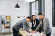 © anatoliycherkas - Close-up shot of group of architects drawing building plan together at office