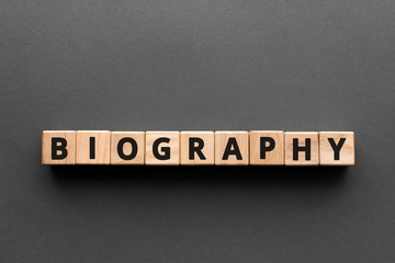 Poster - Biography - words from wooden blocks with letters, the life story biography concept, top view gray background