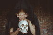 © venerala - a witch holds a human skull