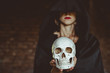 © venerala - a witch holds a human skull