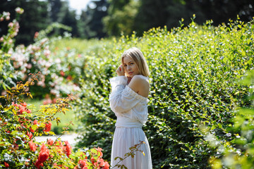 girl in a white dress in a rose garden