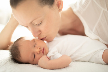 Mother kissing her little new born baby girl. 