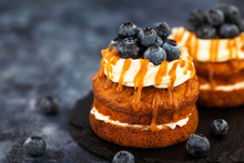 Delicious Carrot Individual Cakes With Caramel Sauce, Cream Cheese Frosting And Fresh Blueberries