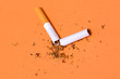 Broken cigarette on orange background