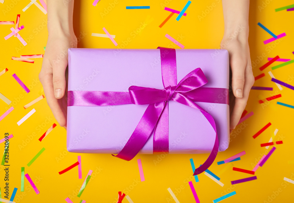 Female hands with beautiful gift box on color background