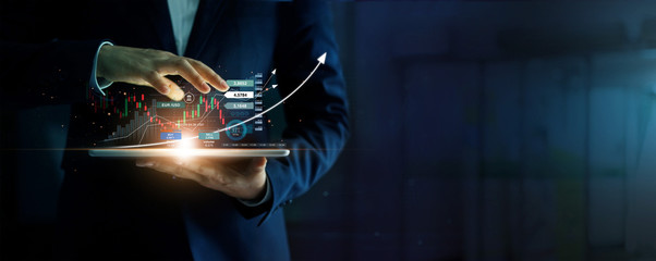Fototapete - Businessman holding tablet and analysis stock market, currency exchange and banking, showing a growing virtual hologram of statistics, graph and chart, Business growth, planing and strategy  concept.