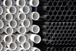 Close-up full frame sectional front view of construction supply stacks of plastic water pipes 
