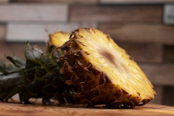 Ripe pineapple cut in two on a wooden cutting board