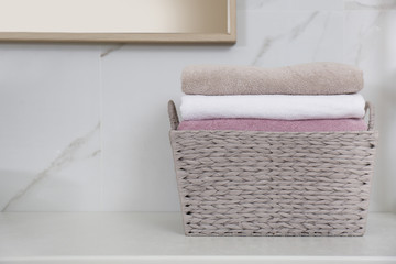 Canvas Print - Laundry basket with fresh towels on counter in bathroom