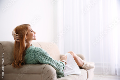 Cuadros en Lienzo Young woman relaxing on couch at home. Space for text