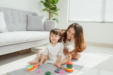 asian mother and daughter playing toy in house