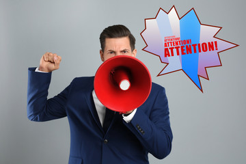 Handsome man with megaphone on grey background